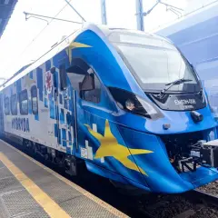 Nowy pociąg hybrydowy EN63H-008 z motywem gwiazd Unii Europejskiej na niebieskim tle, gotowy do podróży.