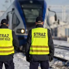 Dwóch funkcjonariuszy Straży Ochrony Kolei w kamizelkach odblaskowych stoi przed pociągiem. Czy mogą wystawić mandat?