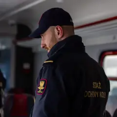 Strażnik kolejowy czuwa nad bezpieczeństwem podróżnych. W razie potrzeby użyje hamulec bezpieczeństwa w pociągu.