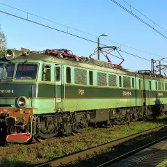 Zielona lokomotywa ET41 PKP z wagonami towarowymi na torach.