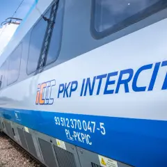 Pociąg PKP Intercity z logo na białym tle, gotowy do podróży po Żuławach.