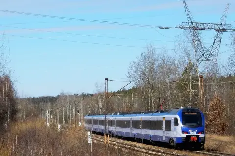 Pociąg ED160 PKP Intercity mija linię energetyczną i las.