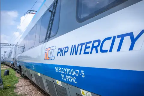 Pociąg PKP Intercity z logo na białym tle, gotowy do podróży po Żuławach.