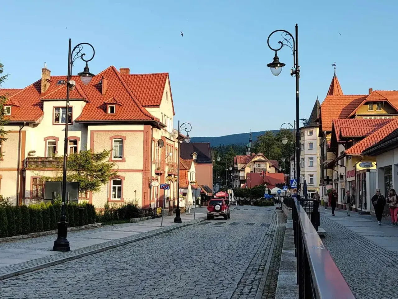 Urokliwa ulica w Świeradowie-Zdroju, z charakterystyczną architekturą i brukowaną nawierzchnią. Idealne miejsce na spacer po okolicy Jeleniej Góry.