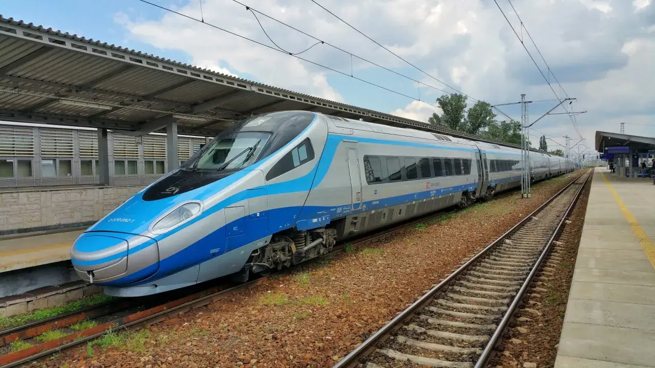 Nowoczesny intercity pendolino czeka na pasażerów na peronie. Pociąg w kolorach niebieskim i srebrnym jest gotowy do podróży.